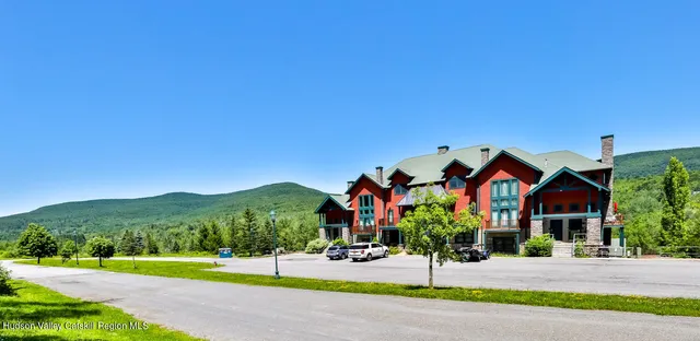 a front view of a house with a yard and road