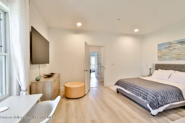 a bedroom with a bed and a flat screen tv