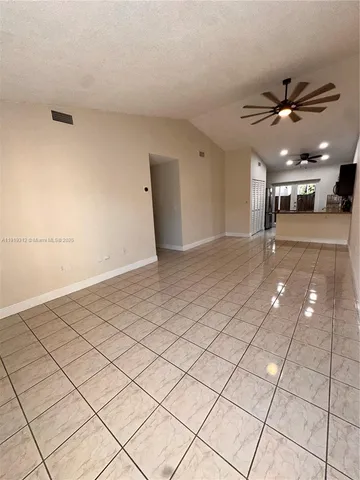 a view of a livingroom and a kitchen space with wooden floor