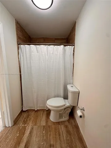 a bathroom with a toilet and a shower curtain