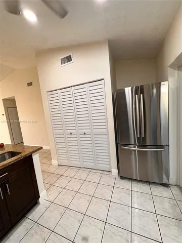 a view of kitchen with refrigerator and microwave