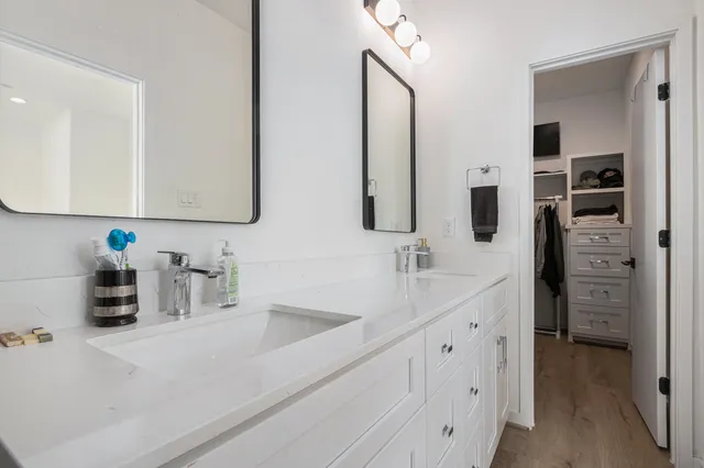a bathroom with double vanity sink and two mirror