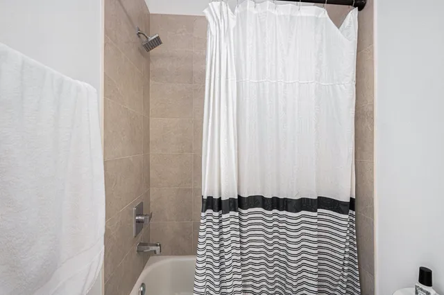 a bedroom with a bed and a curtain