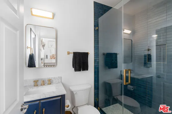 a bathroom with a toilet sink a mirror a shower and vanity