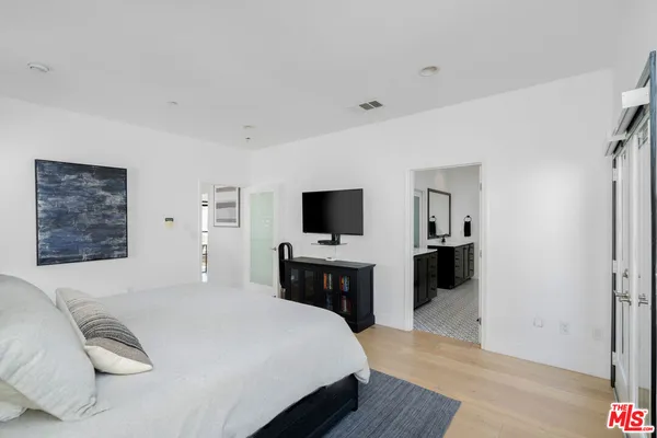 a bedroom with a bed and a flat screen tv