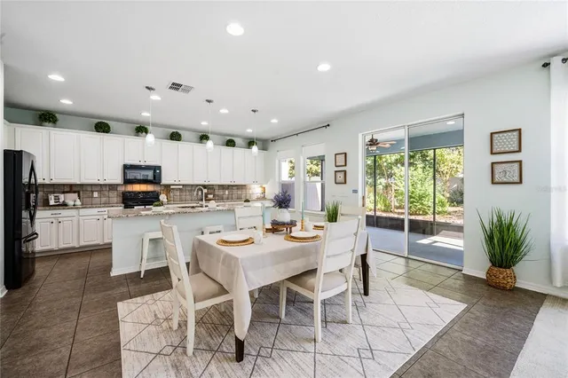 a kitchen with a dining table chairs and refrigerator