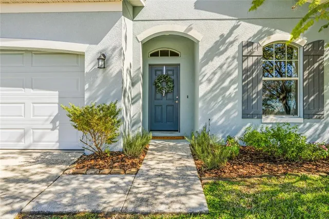 a view of yellow house with a flower garden