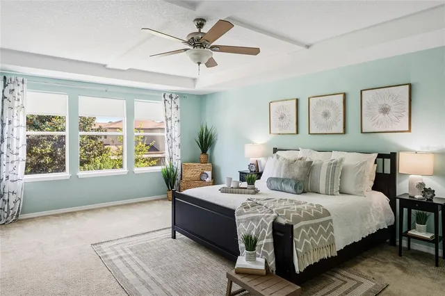 a bedroom with a large bed and a potted plant
