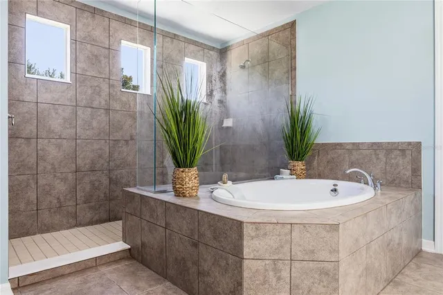 a bathroom with a tub sink and mirror