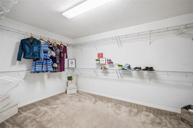a bedroom with a bed table chair and a window