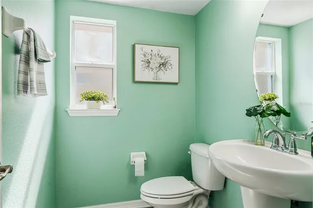 a white toilet sitting next to a bathroom sink