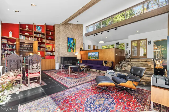 a living room with fireplace furniture and a floor to ceiling window