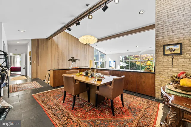 a kitchen with stainless steel appliances granite countertop a stove a sink dishwasher and a dining table with wooden floor