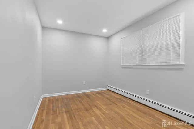 a view of room with wooden floor and cabinet
