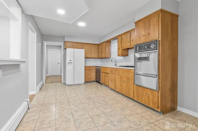 a kitchen with stainless steel appliances a refrigerator sink and cabinets