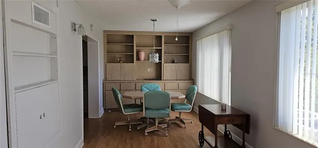 a workspace room with wooden floor windows and cabinet