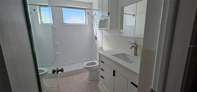 a bathroom with a sink and mirror with toilet