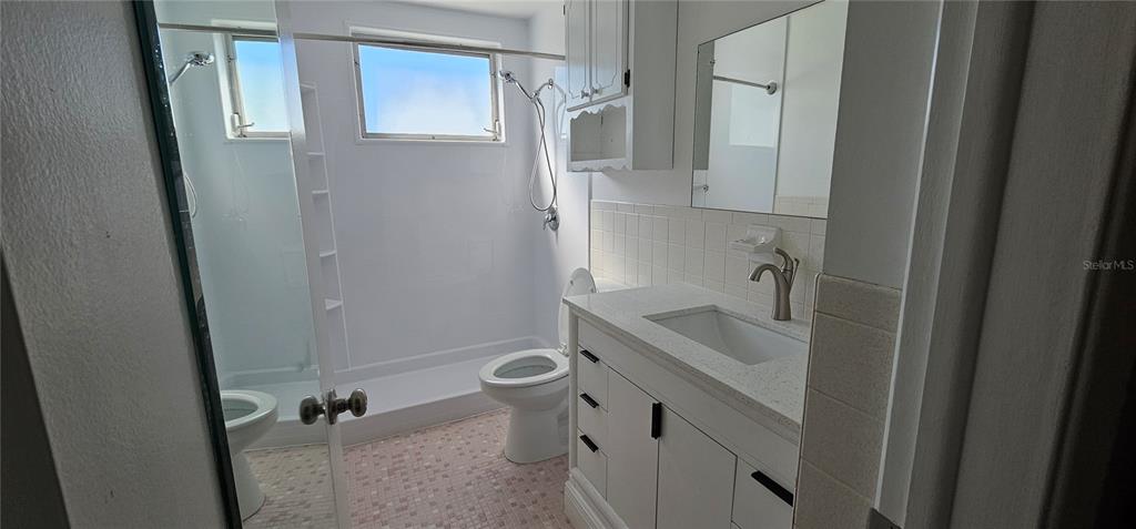 2450 Canadian Way, Unit 26 Clearwater, FL 33763 - Photo 14 of 32 a bathroom with a sink and mirror with toilet