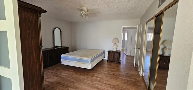 a view of a bedroom with a bed and wooden floor