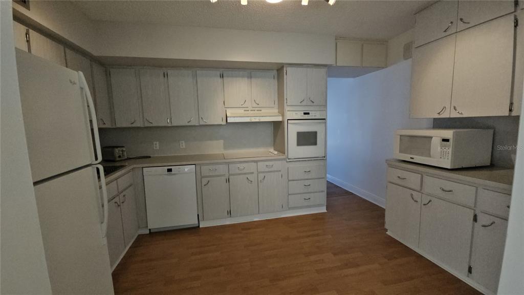 2450 Canadian Way, Unit 26 Clearwater, FL 33763 - Photo 28 of 32 a kitchen with stainless steel appliances white cabinets and a refrigerator