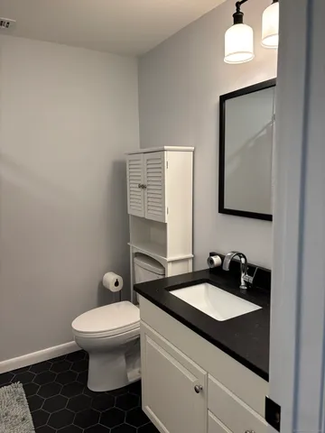 a bathroom with a toilet sink and mirror