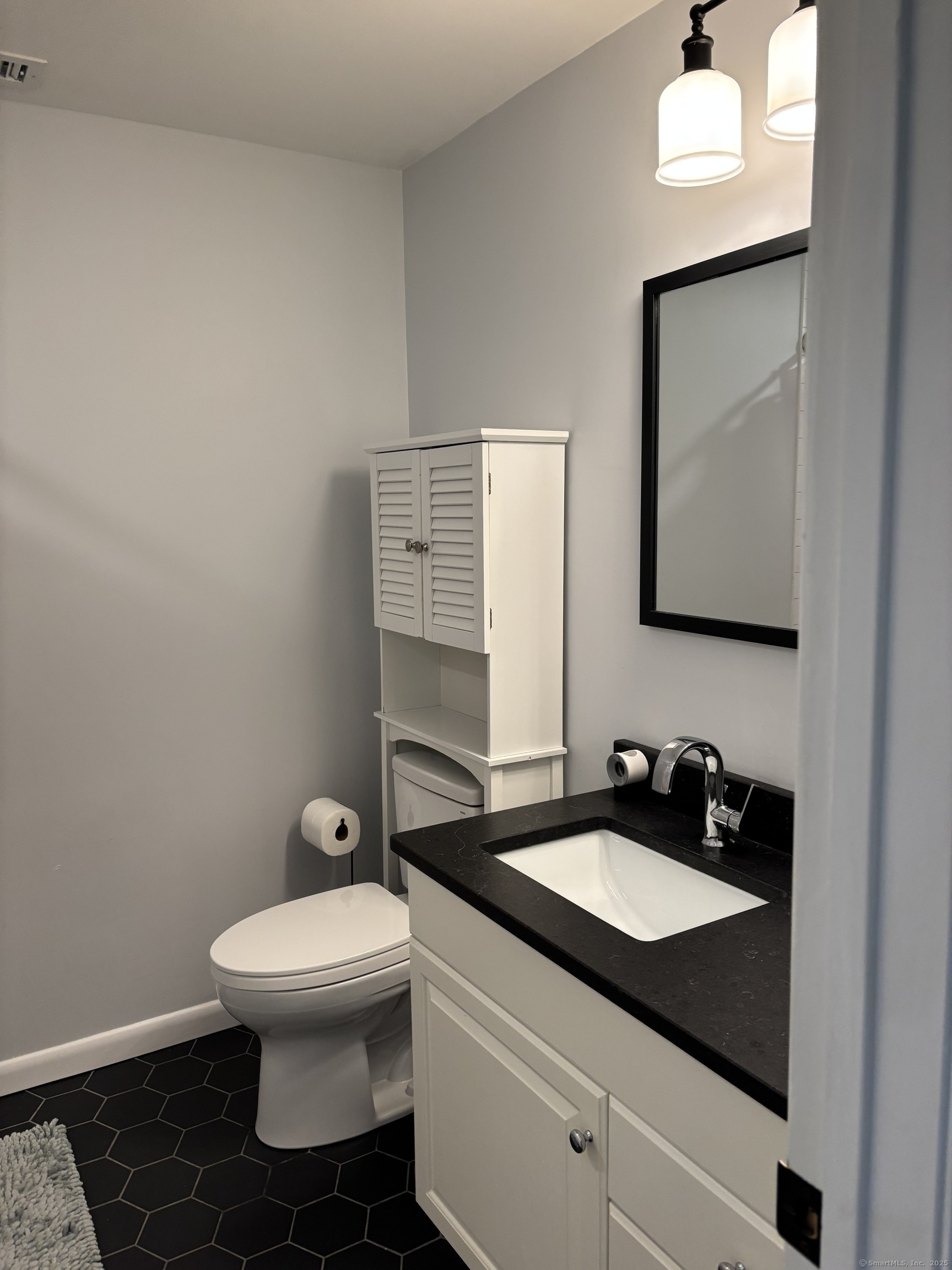 846 Beechwood Road Orange, CT 06477 - Photo 18 of 25 a bathroom with a toilet sink and mirror