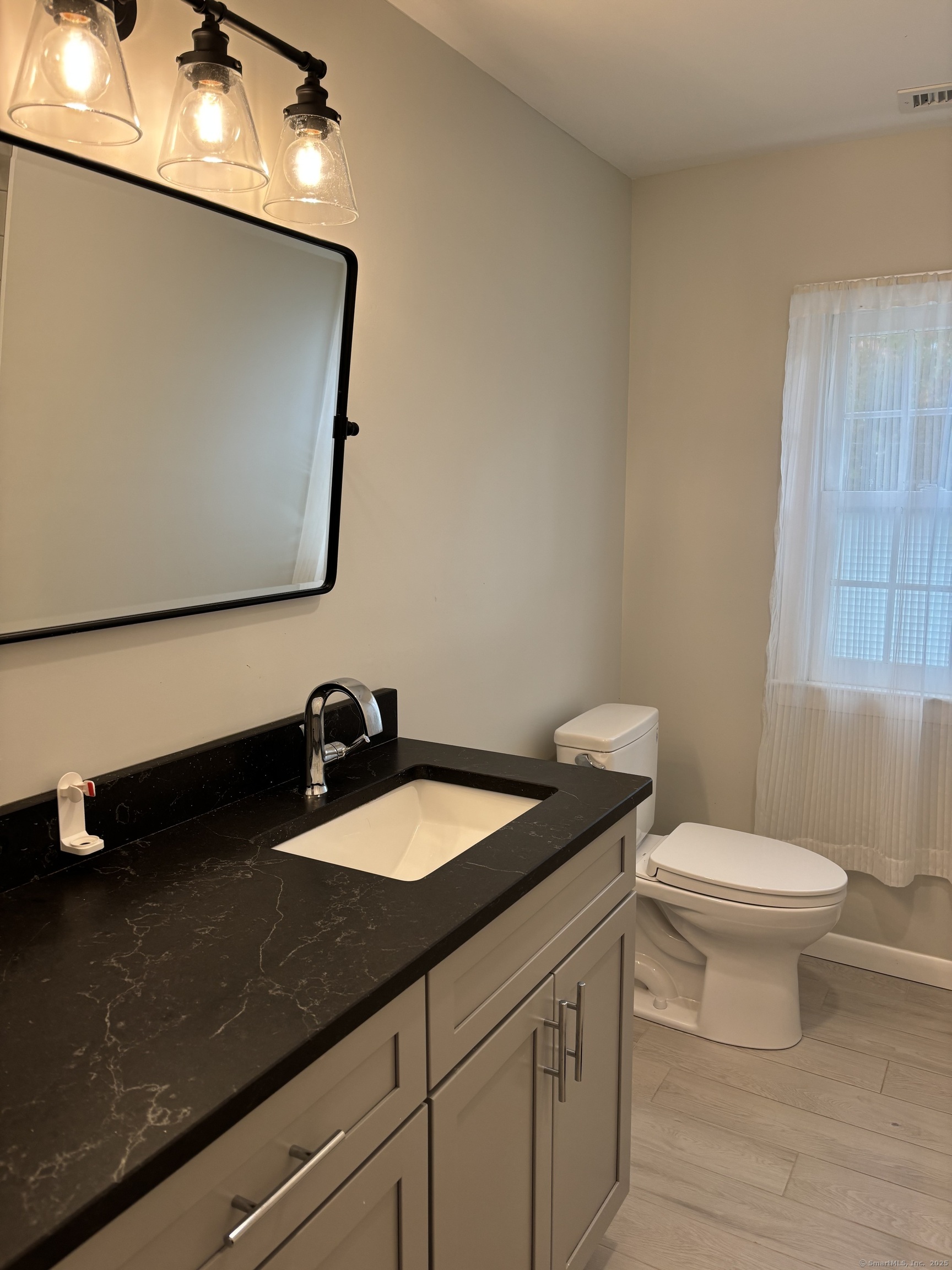 846 Beechwood Road Orange, CT 06477 - Photo 21 of 25 a bathroom with a granite countertop sink and a mirror