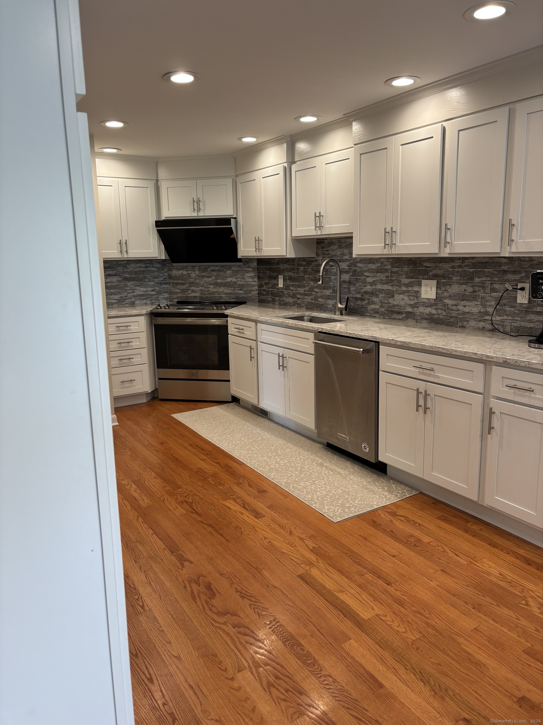 846 Beechwood Road Orange, CT 06477 - Photo 8 of 25 a kitchen with granite countertop a stove top oven and cabinets