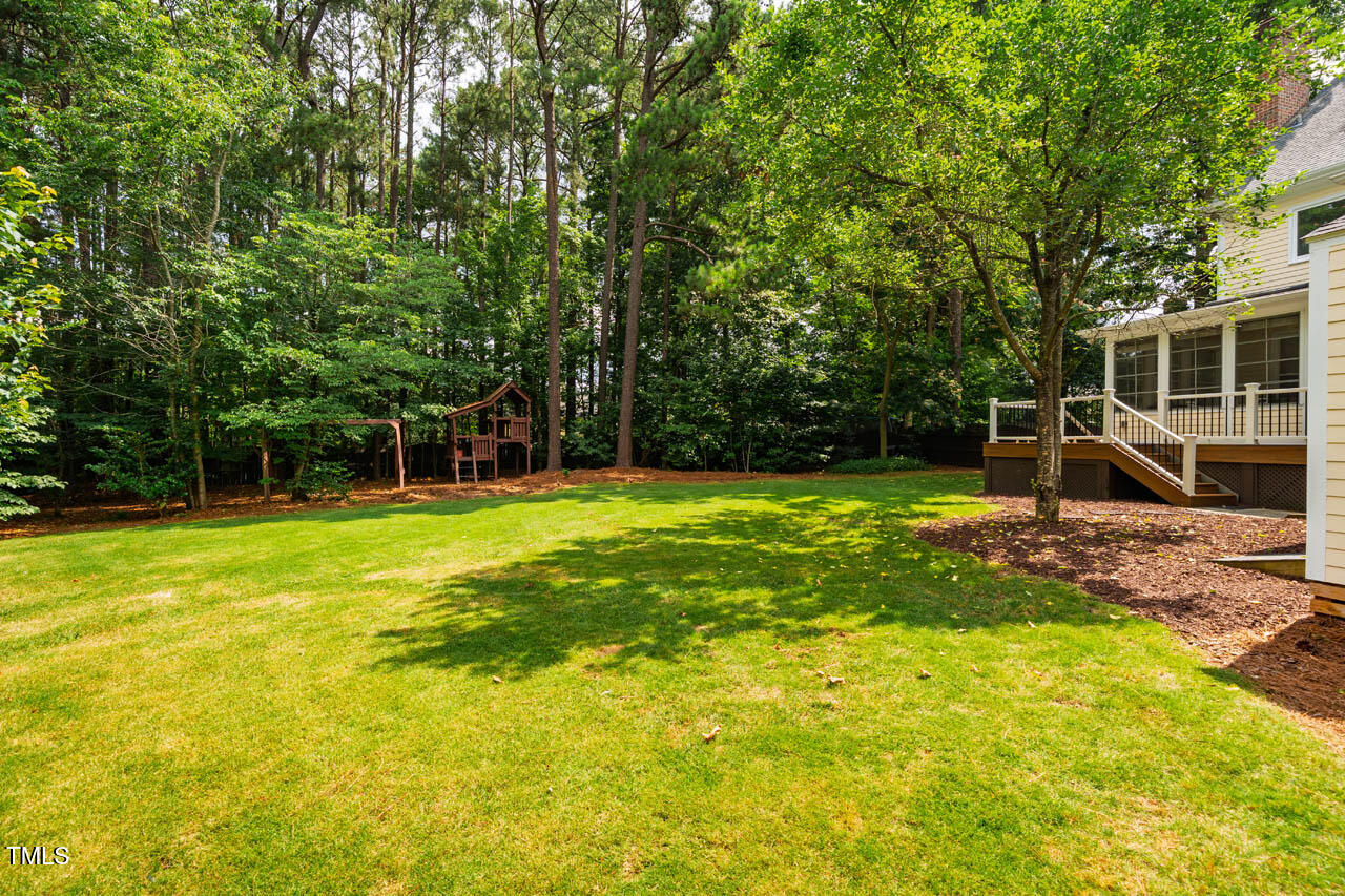 5205 Coffee Tree Drive Raleigh, NC 27613 - Photo 46 of 51 a view of a swimming pool with a bench and trees