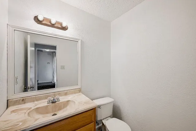 a bathroom with a sink mirror vanity and toilet