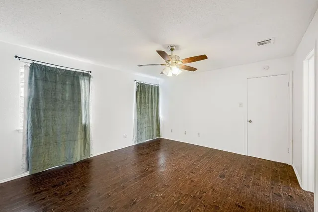 an empty room with closet and a chandelier fan
