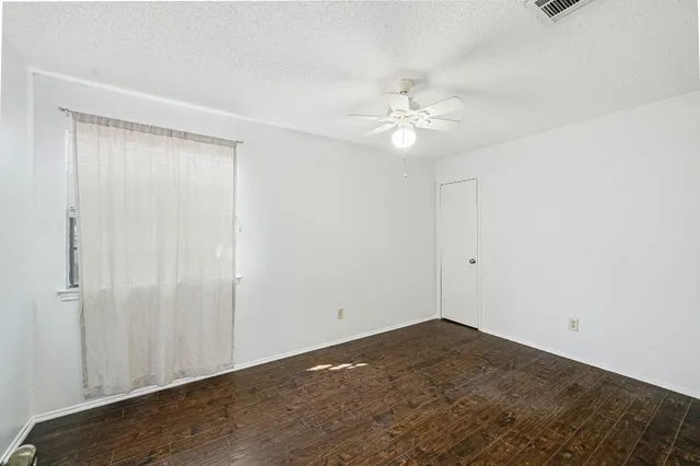 an empty room with a ceiling fan and carpet