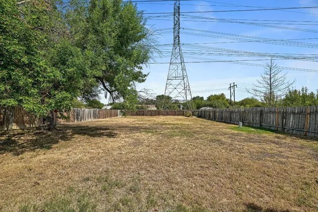 a view of a yard with wooden fence
