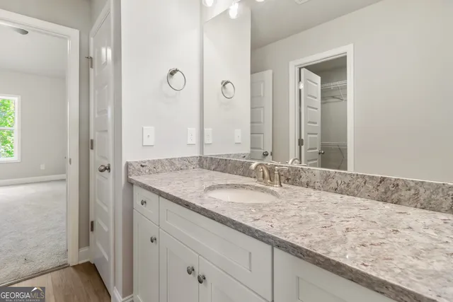 a bathroom with a granite countertop sink and a mirror