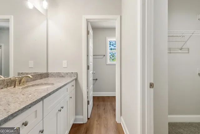 a bathroom with a granite countertop sink and a mirror