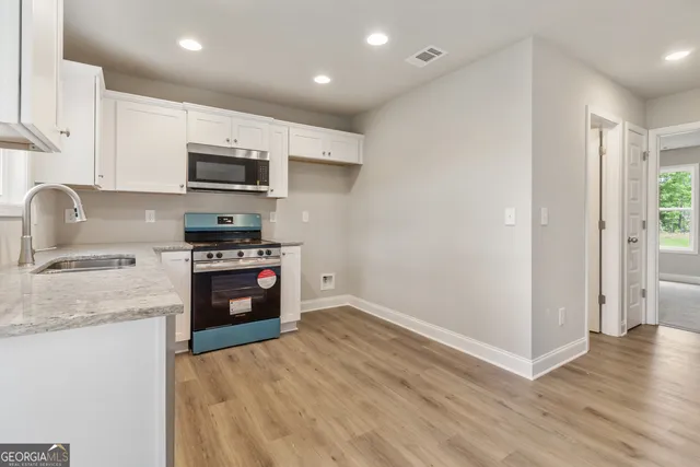 a kitchen with stainless steel appliances a microwave a stove a sink and a refrigerator