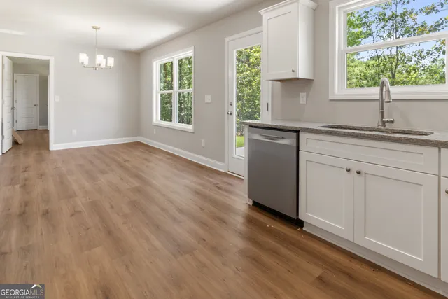 a kitchen with a sink wooden floor and window