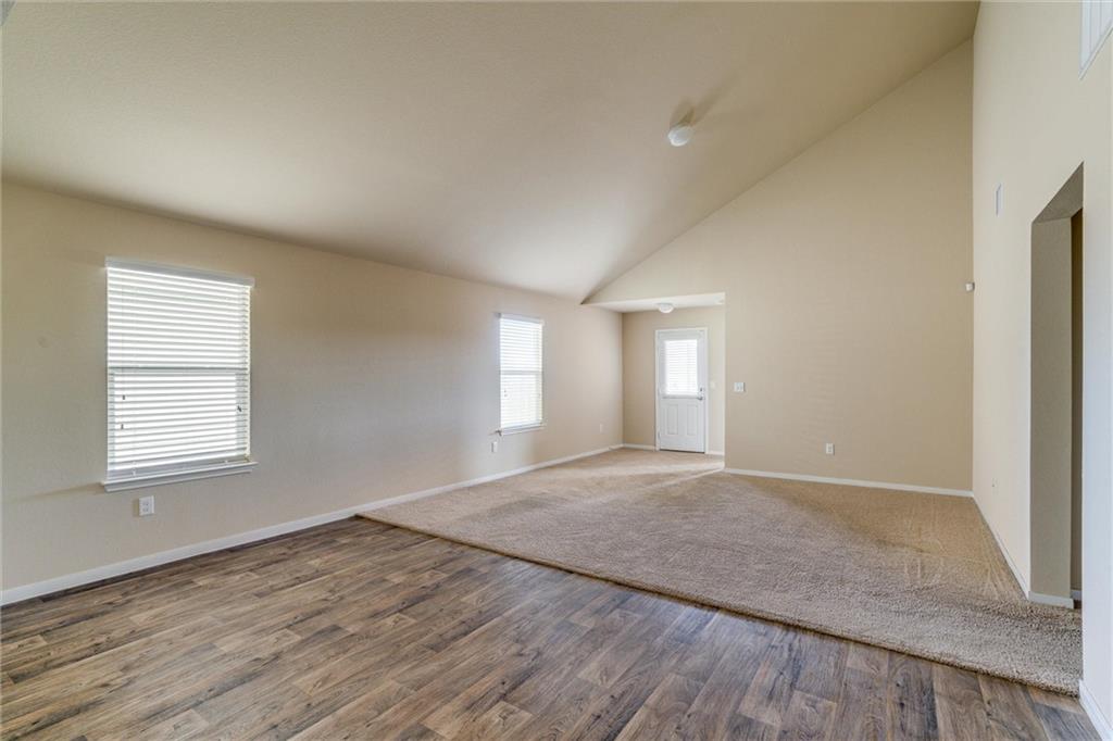 11704 Andesite Road Manor, TX 78653 - Photo 15 of 30 an empty room with wooden floor and windows