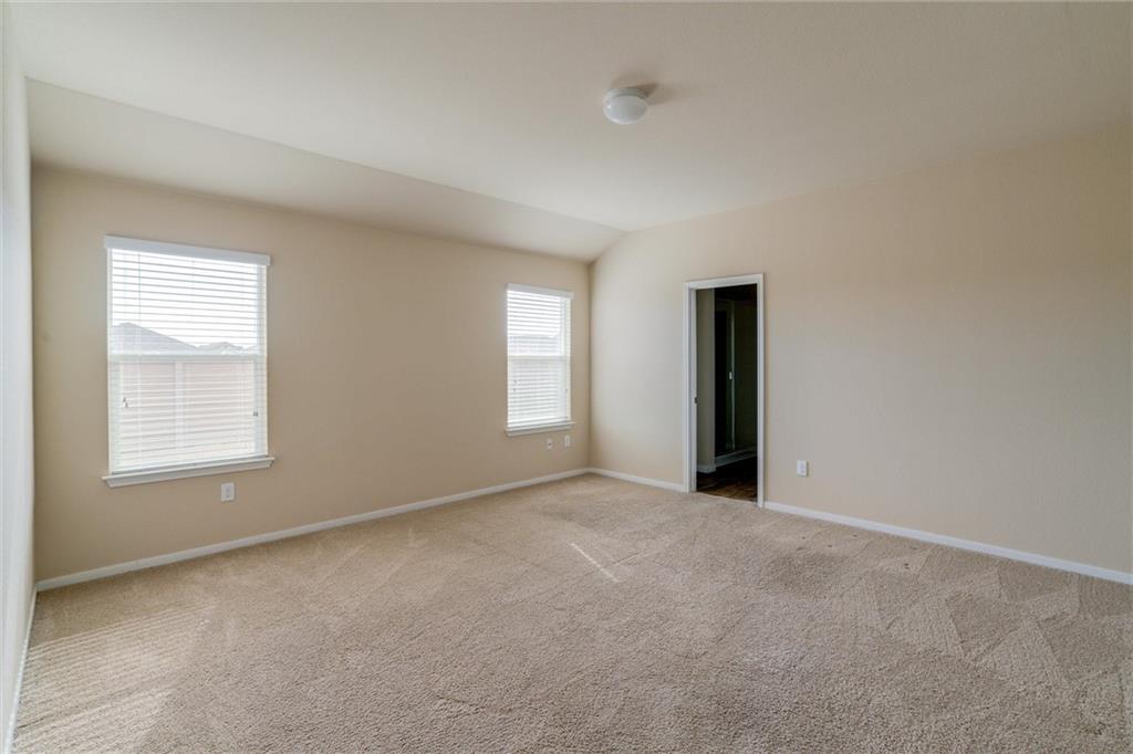 11704 Andesite Road Manor, TX 78653 - Photo 17 of 30 an empty room with windows and closet