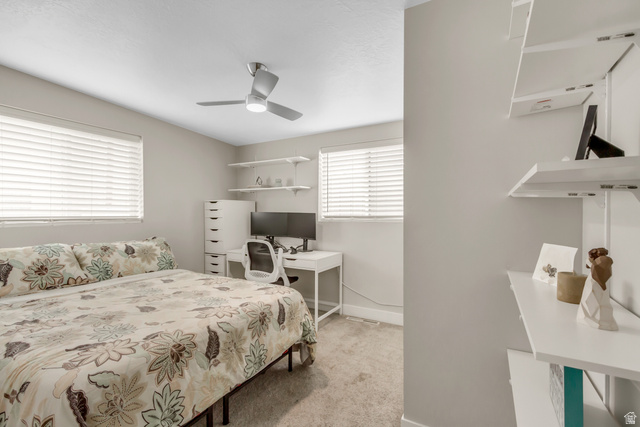 48 Moon Ridge Drive Murray, UT 84107 - Photo 17 of 30 Bedroom featuring two large windows with blinds, a ceiling fan with light fixture, light-toned wall paint, and built-in shelving units