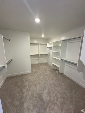 1225 West 500 South Logan, UT 84321 - Photo 38 of 39 Spacious walk-in closet featuring built-in shelving, multiple hanging rods, recessed lighting, and neutral carpeting