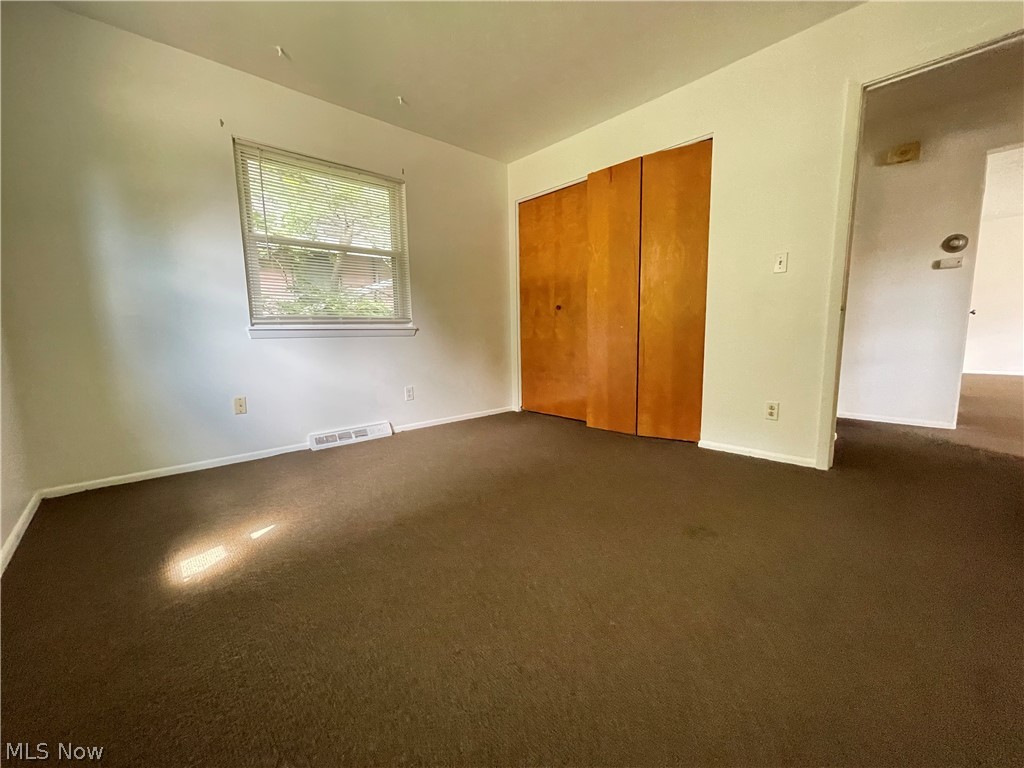 939 Nevin Street Akron, OH 44310 - Photo 11 of 23 Unit A Unfurnished bedroom featuring a closet and dark carpet