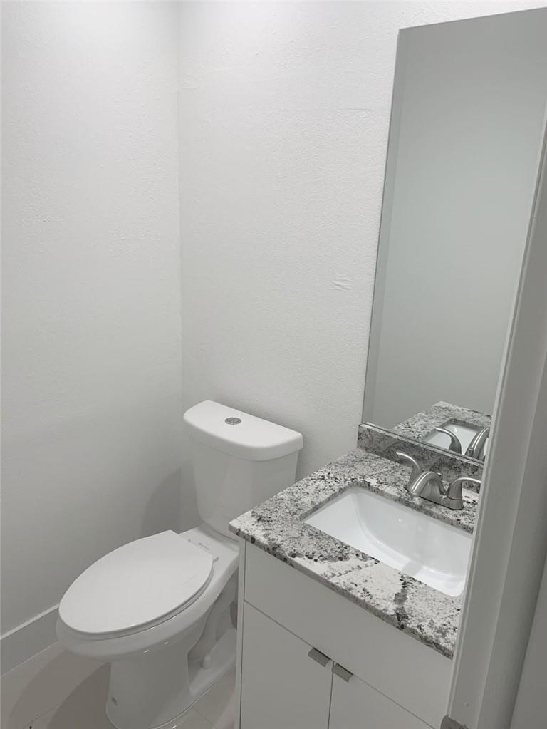 6376 Northwest 173rd Street Hialeah, FL 33015 - Photo 13 of 20 a bathroom with a granite countertop toilet and sink