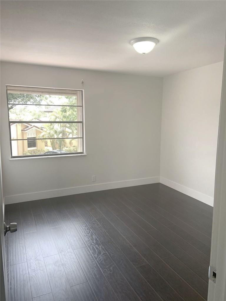 6376 Northwest 173rd Street Hialeah, FL 33015 - Photo 14 of 20 an empty room with wooden floor and windows