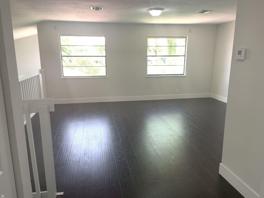 6376 Northwest 173rd Street Hialeah, FL 33015 - Photo 16 of 20 an empty room with wooden floor and windows
