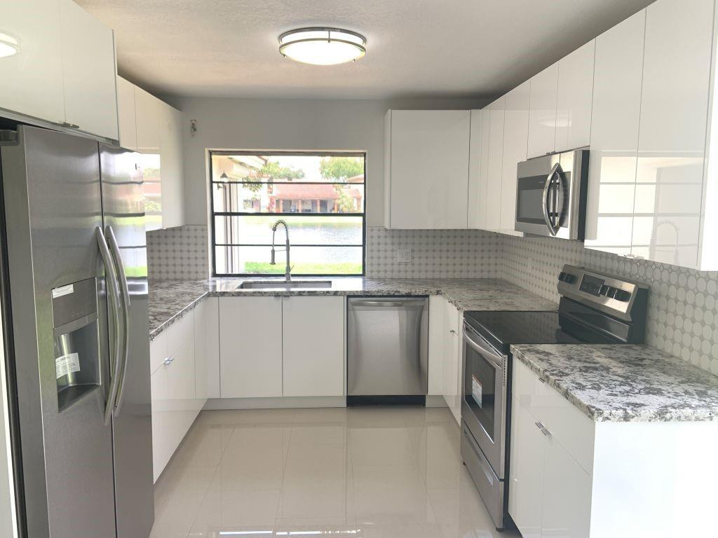 6376 Northwest 173rd Street Hialeah, FL 33015 - Photo 19 of 20 a kitchen with a stove a sink and a refrigerator