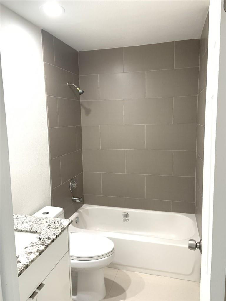 6376 Northwest 173rd Street Hialeah, FL 33015 - Photo 2 of 20 a bathroom with a granite countertop toilet a sink and bathtub