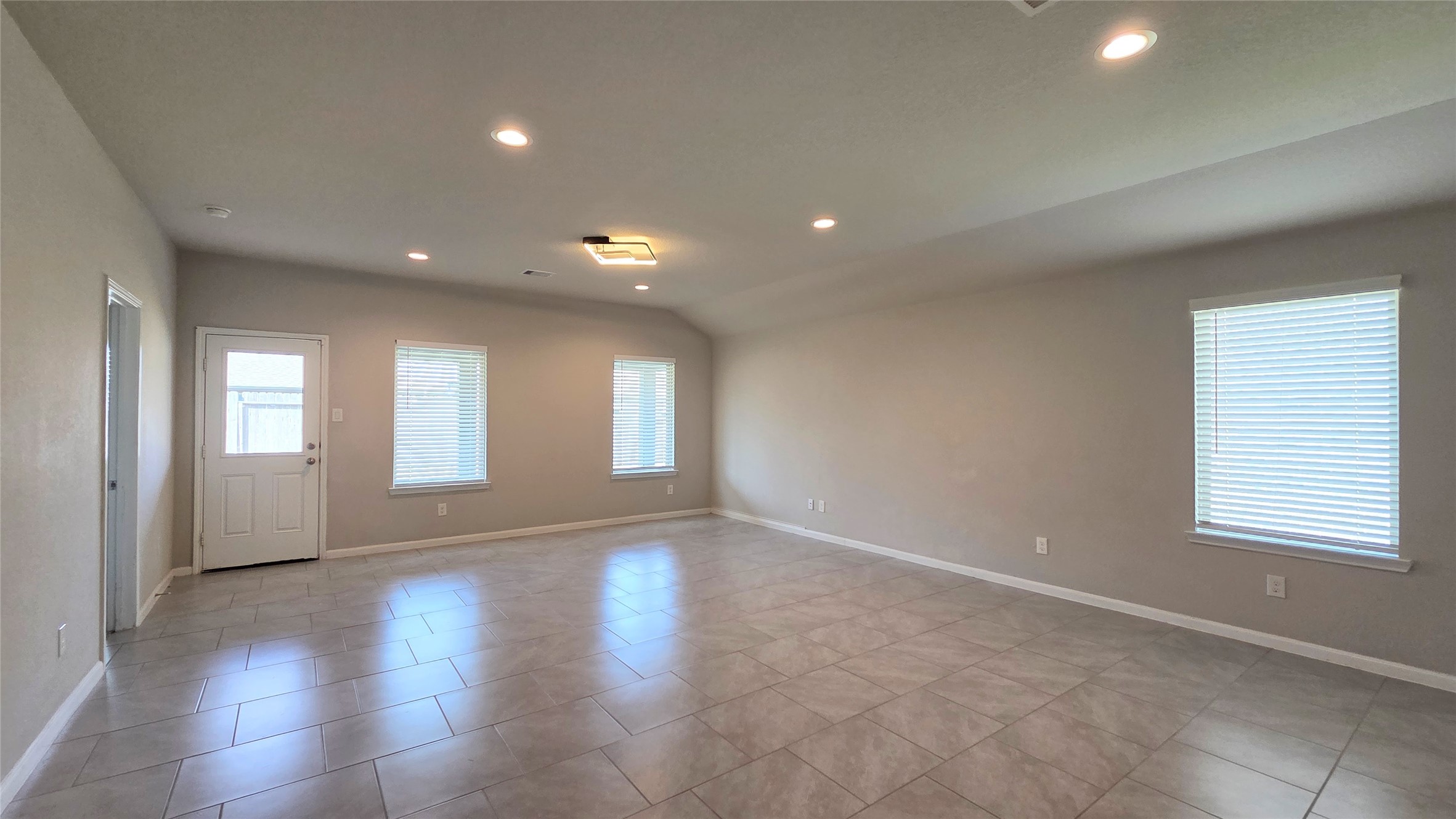 3518 Windham Way Katy, TX 77494 - Photo 7 of 18 an empty room with wooden floor and windows