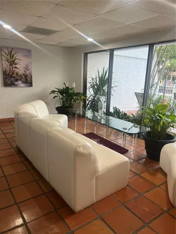 a living room with a couch and a potted plant