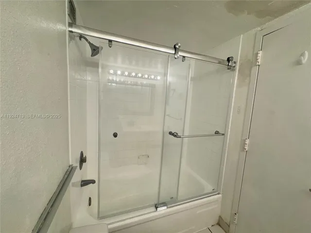 a bathroom with a glass door shower